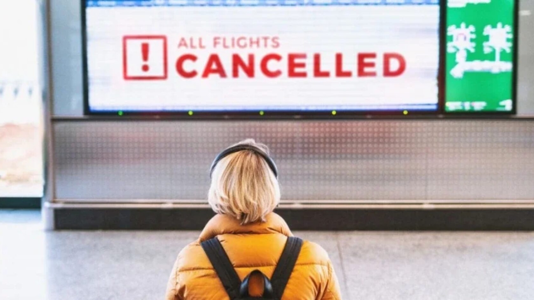 Passenger monitoring cancellations displayed on airport departure screen