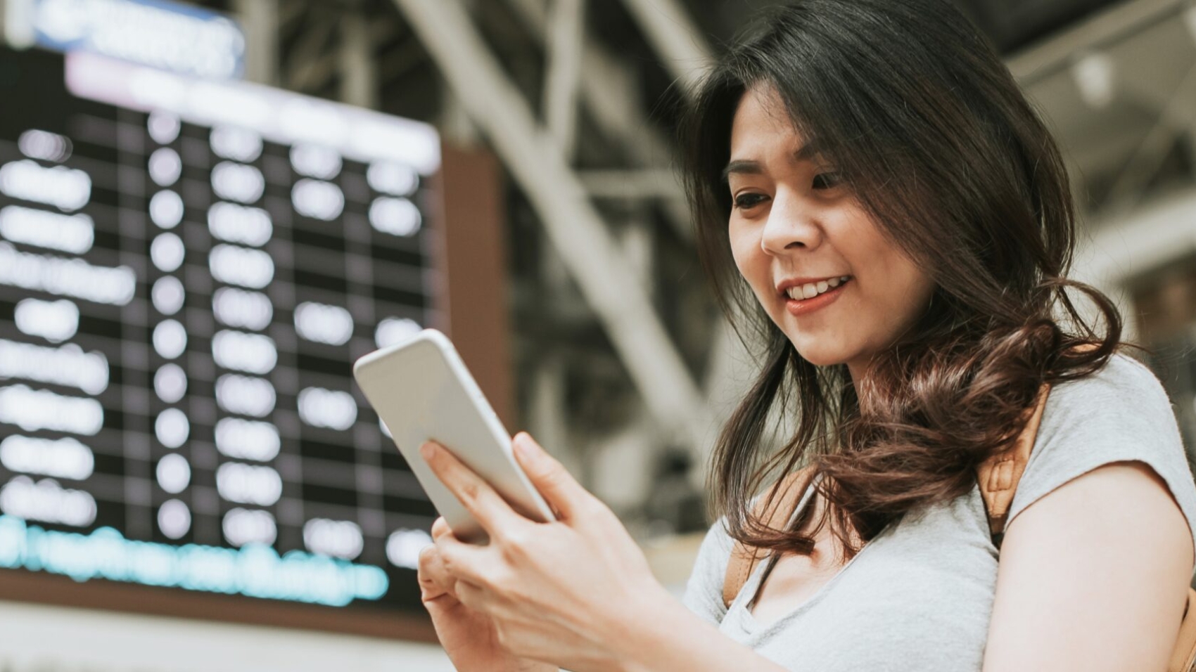 Woman checking refund status on mobile during airline disruption