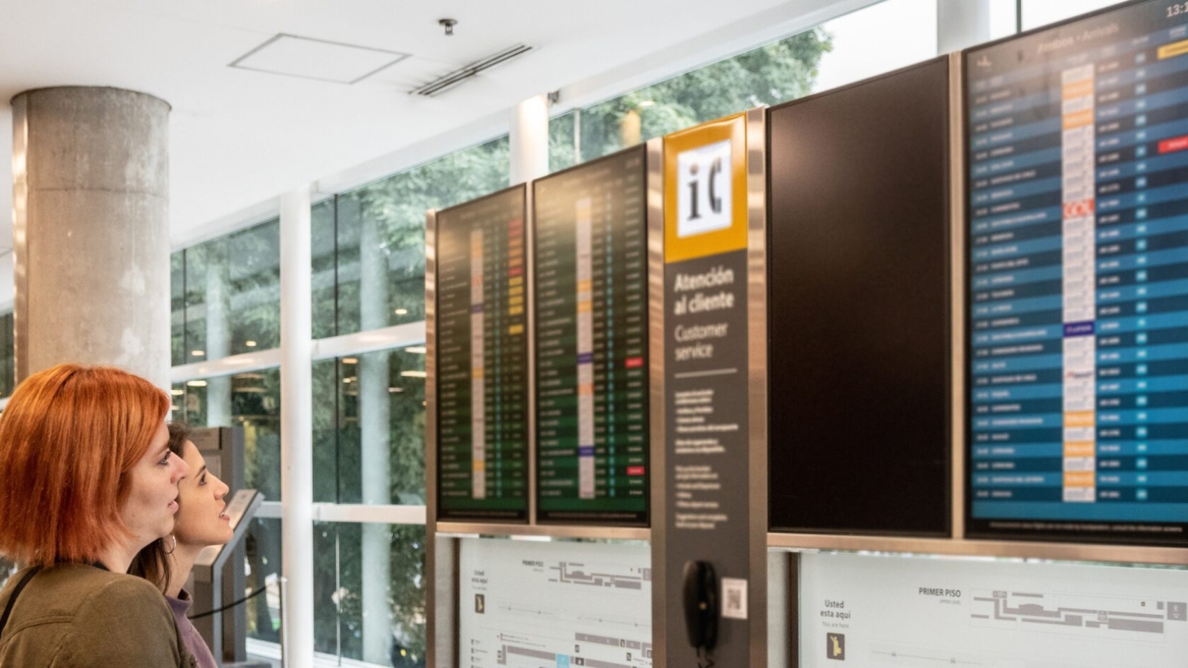 Close view of passengers tracking schedules on digital boards—airline disruption management software.