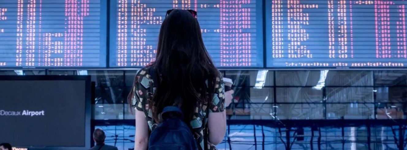 Passenger checking airport departure board during flight delays